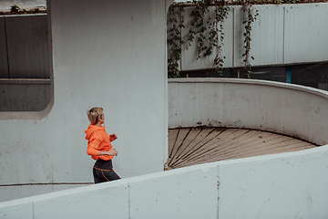 Image showing Women in sports clothes running in a modern urban environment. The concept of a sporty and healthy lifestyle