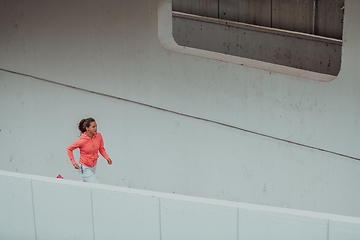 Image showing Women in sports clothes running in a modern urban environment. The concept of a sporty and healthy lifestyle