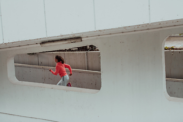 Image showing Women in sports clothes running in a modern urban environment. The concept of a sporty and healthy lifestyle