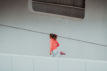 Image showing Women in sports clothes running in a modern urban environment. The concept of a sporty and healthy lifestyle