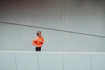 Image showing Women in sports clothes running in a modern urban environment. The concept of a sporty and healthy lifestyle