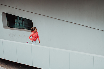 Image showing Women in sports clothes running in a modern urban environment. The concept of a sporty and healthy lifestyle