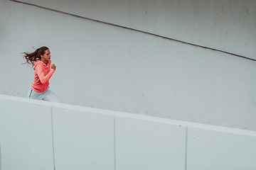 Image showing Women in sports clothes running in a modern urban environment. The concept of a sporty and healthy lifestyle