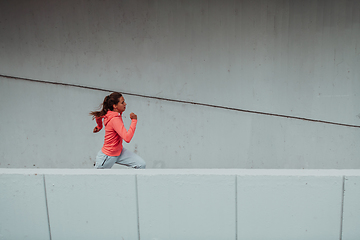 Image showing Women in sports clothes running in a modern urban environment. The concept of a sporty and healthy lifestyle