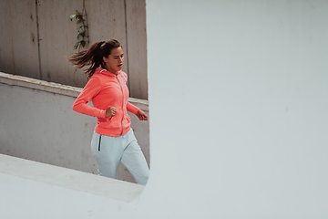 Image showing Women in sports clothes running in a modern urban environment. The concept of a sporty and healthy lifestyle