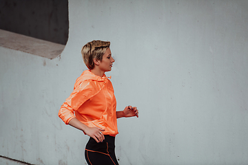 Image showing Women in sports clothes running in a modern urban environment. The concept of a sporty and healthy lifestyle