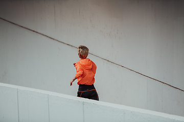 Image showing Women in sports clothes running in a modern urban environment. The concept of a sporty and healthy lifestyle