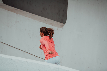 Image showing Women in sports clothes running in a modern urban environment. The concept of a sporty and healthy lifestyle