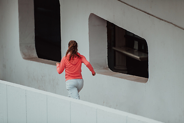 Image showing Women in sports clothes running in a modern urban environment. The concept of a sporty and healthy lifestyle