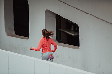 Image showing Women in sports clothes running in a modern urban environment. The concept of a sporty and healthy lifestyle