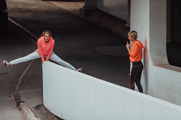 Image showing Two women in sports clothes running in a modern urban environment. The concept of a sporty and healthy lifestyle