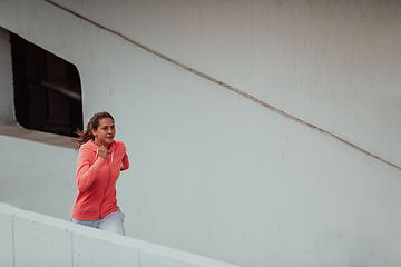 Image showing Women in sports clothes running in a modern urban environment. The concept of a sporty and healthy lifestyle