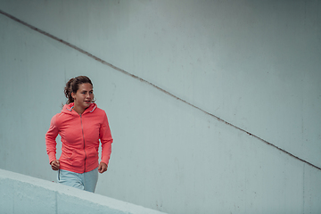 Image showing Women in sports clothes running in a modern urban environment. The concept of a sporty and healthy lifestyle