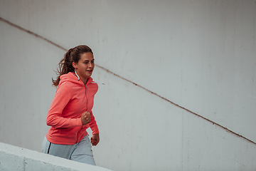 Image showing Women in sports clothes running in a modern urban environment. The concept of a sporty and healthy lifestyle