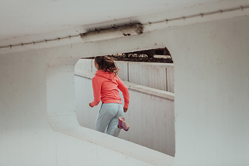 Image showing Women in sports clothes running in a modern urban environment. The concept of a sporty and healthy lifestyle