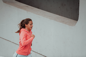 Image showing Women in sports clothes running in a modern urban environment. The concept of a sporty and healthy lifestyle