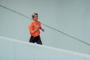 Image showing Women in sports clothes running in a modern urban environment. The concept of a sporty and healthy lifestyle