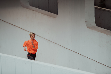 Image showing Women in sports clothes running in a modern urban environment. The concept of a sporty and healthy lifestyle