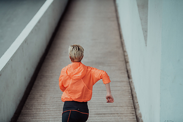 Image showing Women in sports clothes running in a modern urban environment. The concept of a sporty and healthy lifestyle