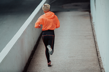 Image showing Women in sports clothes running in a modern urban environment. The concept of a sporty and healthy lifestyle