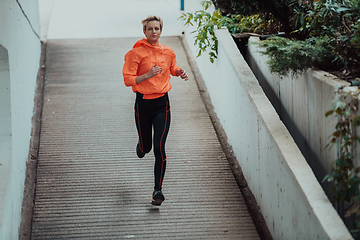 Image showing Women in sports clothes running in a modern urban environment. The concept of a sporty and healthy lifestyle