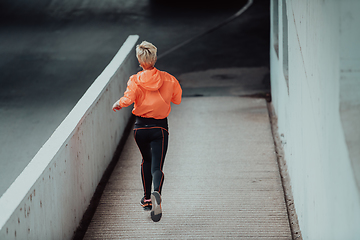 Image showing Women in sports clothes running in a modern urban environment. The concept of a sporty and healthy lifestyle