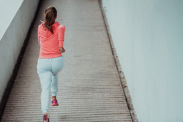 Image showing Women in sports clothes running in a modern urban environment. The concept of a sporty and healthy lifestyle