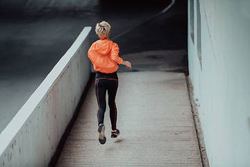 Image showing Women in sports clothes running in a modern urban environment. The concept of a sporty and healthy lifestyle