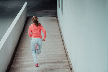 Image showing Women in sports clothes running in a modern urban environment. The concept of a sporty and healthy lifestyle