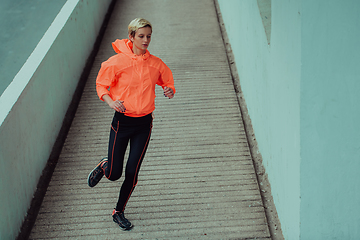 Image showing Women in sports clothes running in a modern urban environment. The concept of a sporty and healthy lifestyle