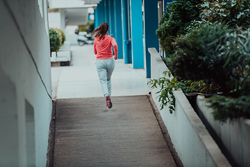 Image showing Women in sports clothes running in a modern urban environment. The concept of a sporty and healthy lifestyle