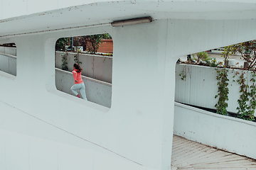 Image showing Women in sports clothes running in a modern urban environment. The concept of a sporty and healthy lifestyle