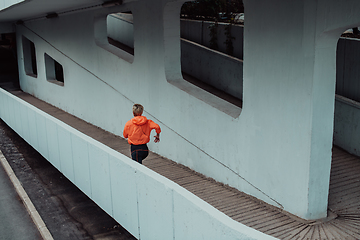 Image showing Women in sports clothes running in a modern urban environment. The concept of a sporty and healthy lifestyle