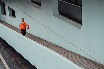 Image showing Women in sports clothes running in a modern urban environment. The concept of a sporty and healthy lifestyle