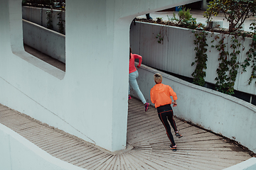 Image showing Two women in sports clothes running in a modern urban environment. The concept of a sporty and healthy lifestyle