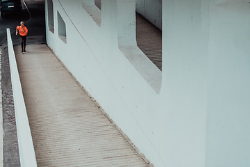 Image showing Women in sports clothes running in a modern urban environment. The concept of a sporty and healthy lifestyle