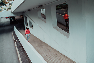 Image showing Two women in sports clothes running in a modern urban environment. The concept of a sporty and healthy lifestyle