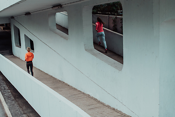 Image showing Two women in sports clothes running in a modern urban environment. The concept of a sporty and healthy lifestyle