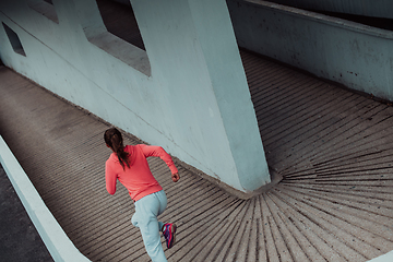 Image showing Women in sports clothes running in a modern urban environment. The concept of a sporty and healthy lifestyle