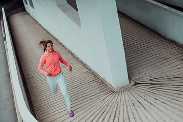 Image showing Women in sports clothes running in a modern urban environment. The concept of a sporty and healthy lifestyle