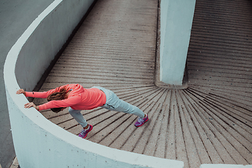 Image showing Fit attractive woman in sportswear stretching before jogging. Workout, sport, activity, fitness, vacation and training concept.