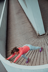 Image showing Fit attractive woman in sportswear stretching before jogging. Workout, sport, activity, fitness, vacation and training concept.