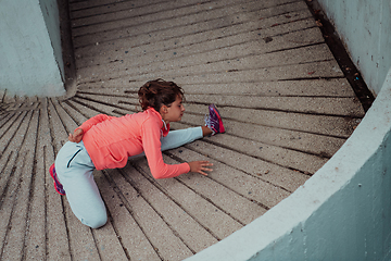 Image showing Fit attractive woman in sportswear stretching before jogging. Workout, sport, activity, fitness, vacation and training concept.