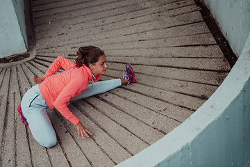 Image showing Fit attractive woman in sportswear stretching before jogging. Workout, sport, activity, fitness, vacation and training concept.