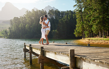 Image showing Love, couple and dance at lake pier, smile and bonding together outdoors on vacation. Dancing date, having fun and happy man and woman on anniversary celebration for romantic holiday at summer creek.