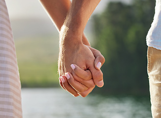 Image showing Holding hands, love and couple at lake outdoors for commitment, trust and support. Romantic date, care and woman and man together for romance, bonding and affection with soulmate at creek on vacation