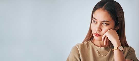 Image showing Woman, thinking and space for idea in studio with . advertising or product placement mockup. Face of female on white background serious, doubt or planning and contemplating logo or branding decision