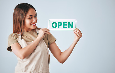 Image showing Coffee shop, small business and woman holding an open sign in studio on a gray background for hospitality. Cafe, startup and management with a female entrepreneur indoor to display advertising