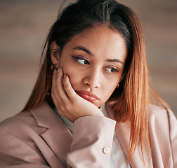 Image showing Face, thinking and depression with a woman feeling or looking sad and alone on a blurred background. Mental health, down and lonely with an unhappy or miserable young female sitting hand on chin