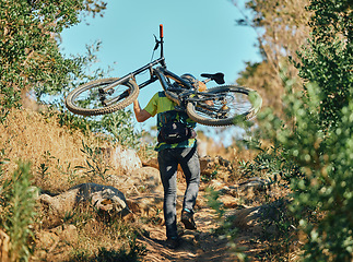 Image showing Back, man and carrying bicycle in nature, walking and traveling outdoor in woods. Sports, fitness and male cyclist or athlete carry mountain bike for exercise, training or workout for transportation.